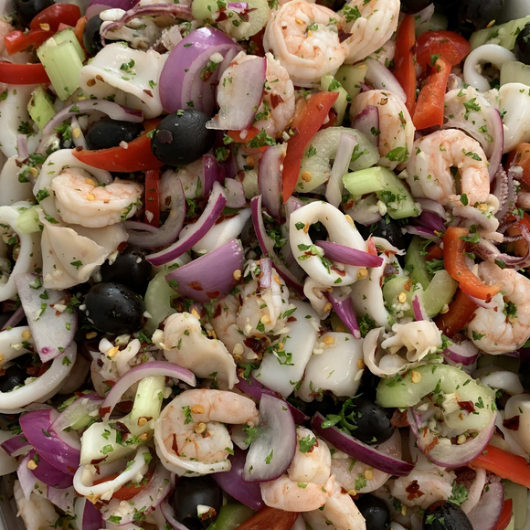 Calamari salad with shrimp cucumbers red peppers onion.